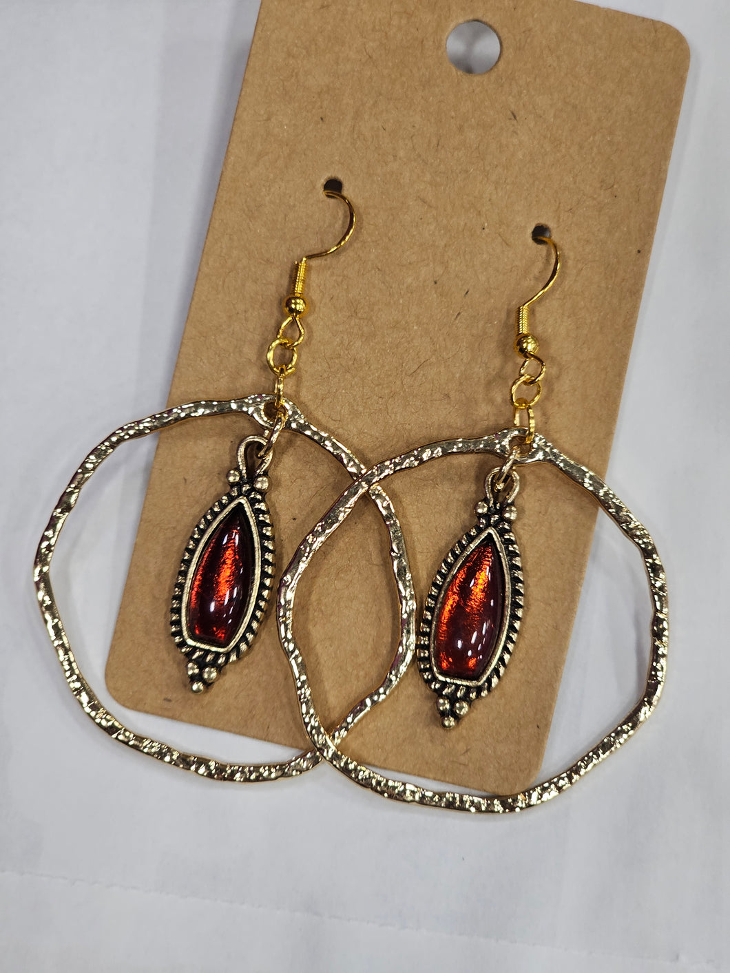 Gold hoop with red charm