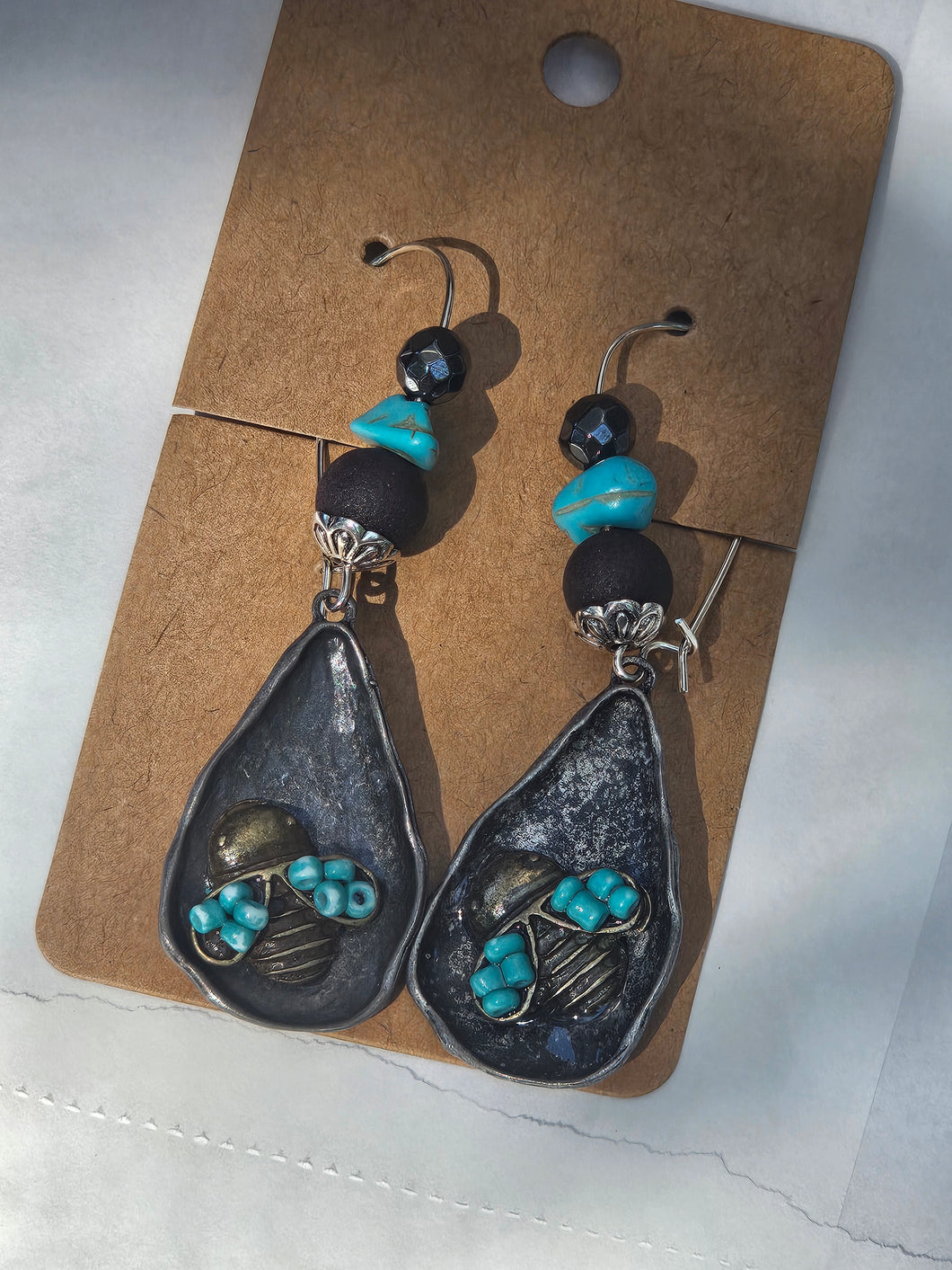 Metal bee with beaded connector on kidney wire.