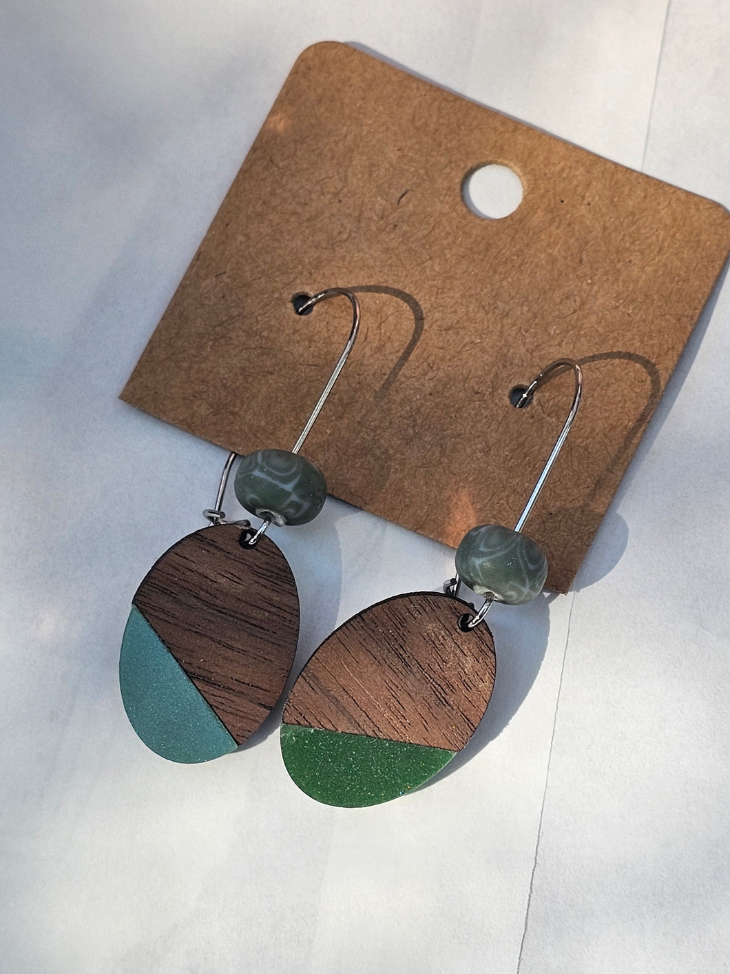 Wood and acrylic oval with clay bead on kidney wire